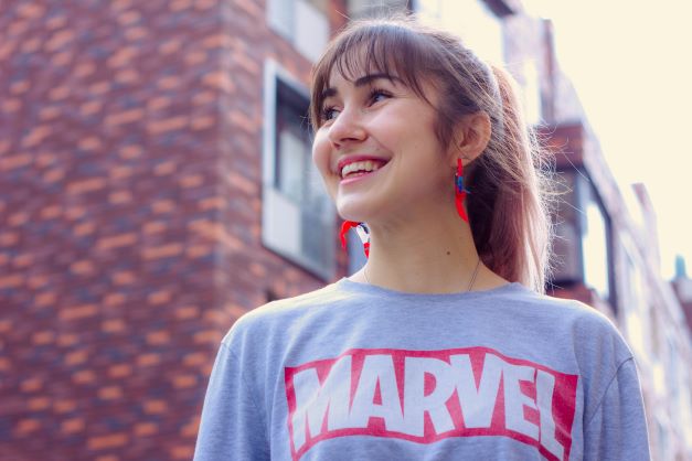 smiling woman wearing a gray t-shirt with Marvel logo